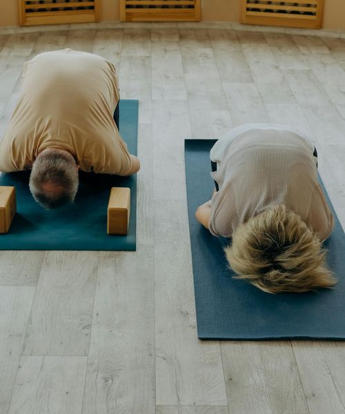 Person practicing a calm yoga pose in a minimalist lavender room.